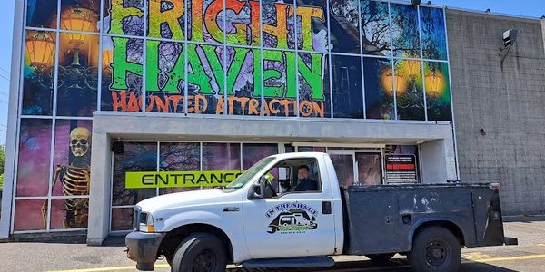 White and black truck parked outside Fright Haven Haunted Attraction entrance.