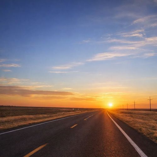 Open highway leading to an open sky and sunset.