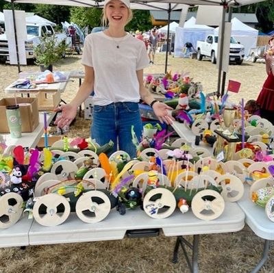 Person posing behind many zucchini race cars
