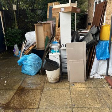 Pile of discarded household items and trash bags.