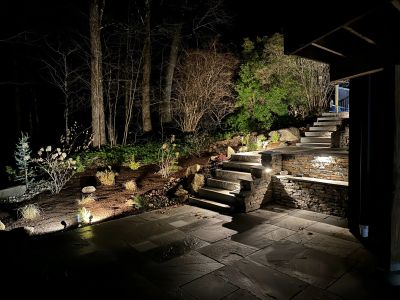 Outdoor stone staircase with lighting at night.