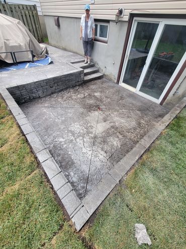 Gorgeous and functional walkout basement retaining wall and stamped pad