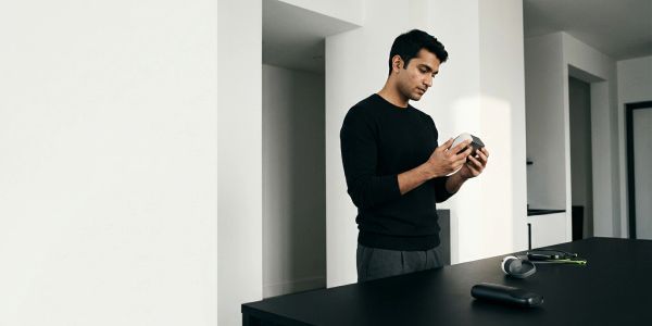 Man examining a white device in a modern kitchen.