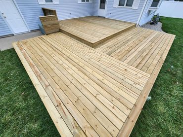 Newly built wooden deck attached to a house with fresh wood planks.