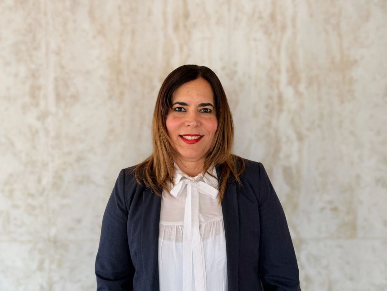 Professional woman in formal attire smiling.