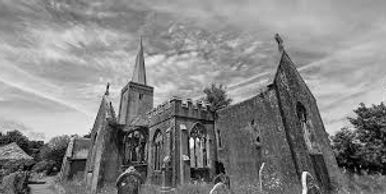 Historic stone church with tall spire under a blue sky.