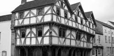 Historic Tudor-style timber-framed building with white and dark wooden beams.