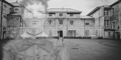 Ghostly image of a woman superimposed on an old prison yard.