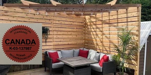 Cozy outdoor seating area with wooden privacy walls and string lights.
