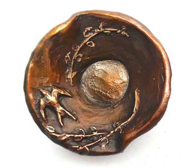 A bowl with a swallow and vines.  Has three leaf feet