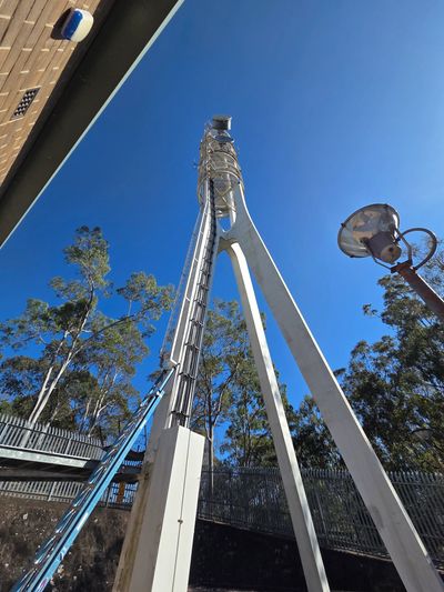 Tall white communication tower against a clear blue sky.