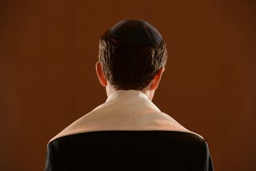A young man reading the Torah at his Bar Mitzvah during his staging photoshoot.