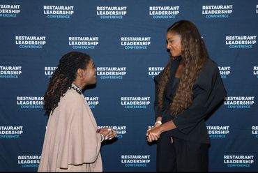 Two women engaged in conversation at the Restaurant Leadership Conference.