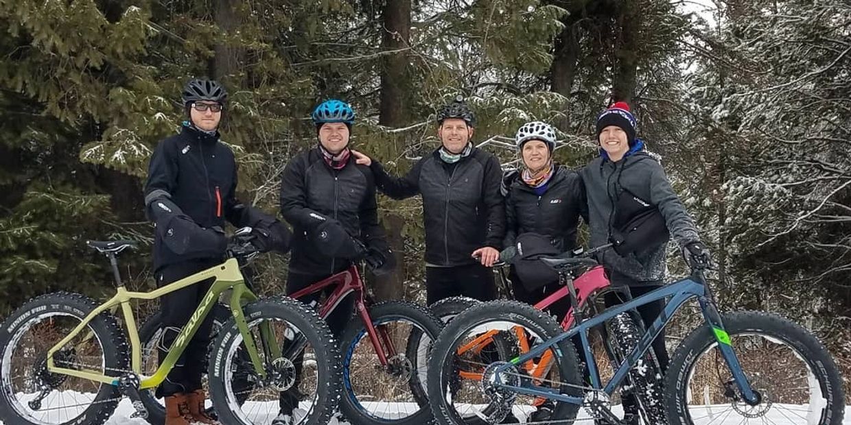 Dave's family standing together behind their fleet of bikes in the snow.