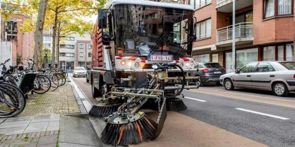 Street cleaning machine sweeping the roadside.