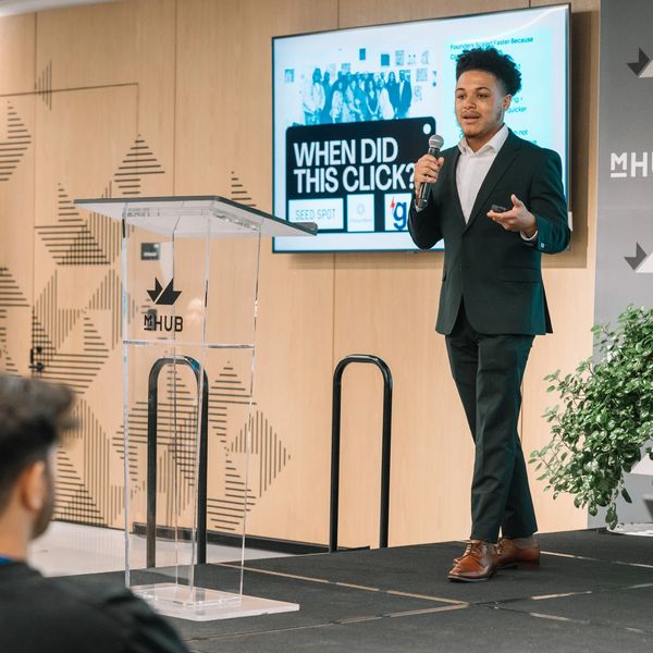 Man giving a presentation with a screen behind him.