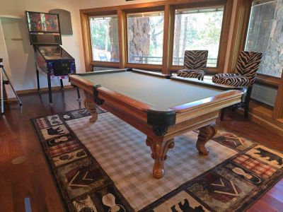 Game room with pool table and pinball machine.