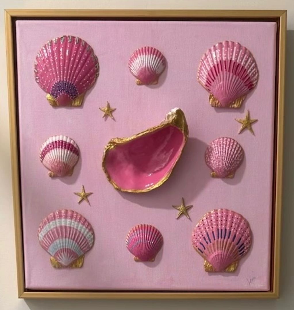Framed artwork of pink seashells and starfish.