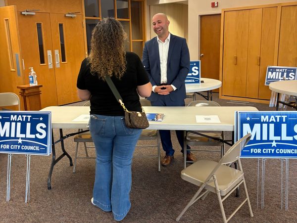 Man speaking with woman at a political event.