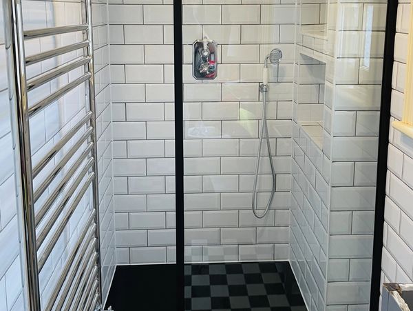 bathroom shower with white tile wall