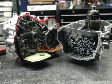 Disassembled automotive transmission components on a workbench.