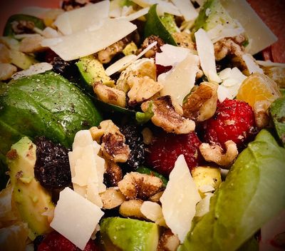 Fresh spinach salad with walnuts, raspberries, avocado, and parmesan.