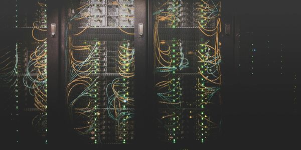 Server racks with cables and blinking lights in a data center.