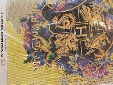 Diamond painting canvas with colorful floral design and tools.