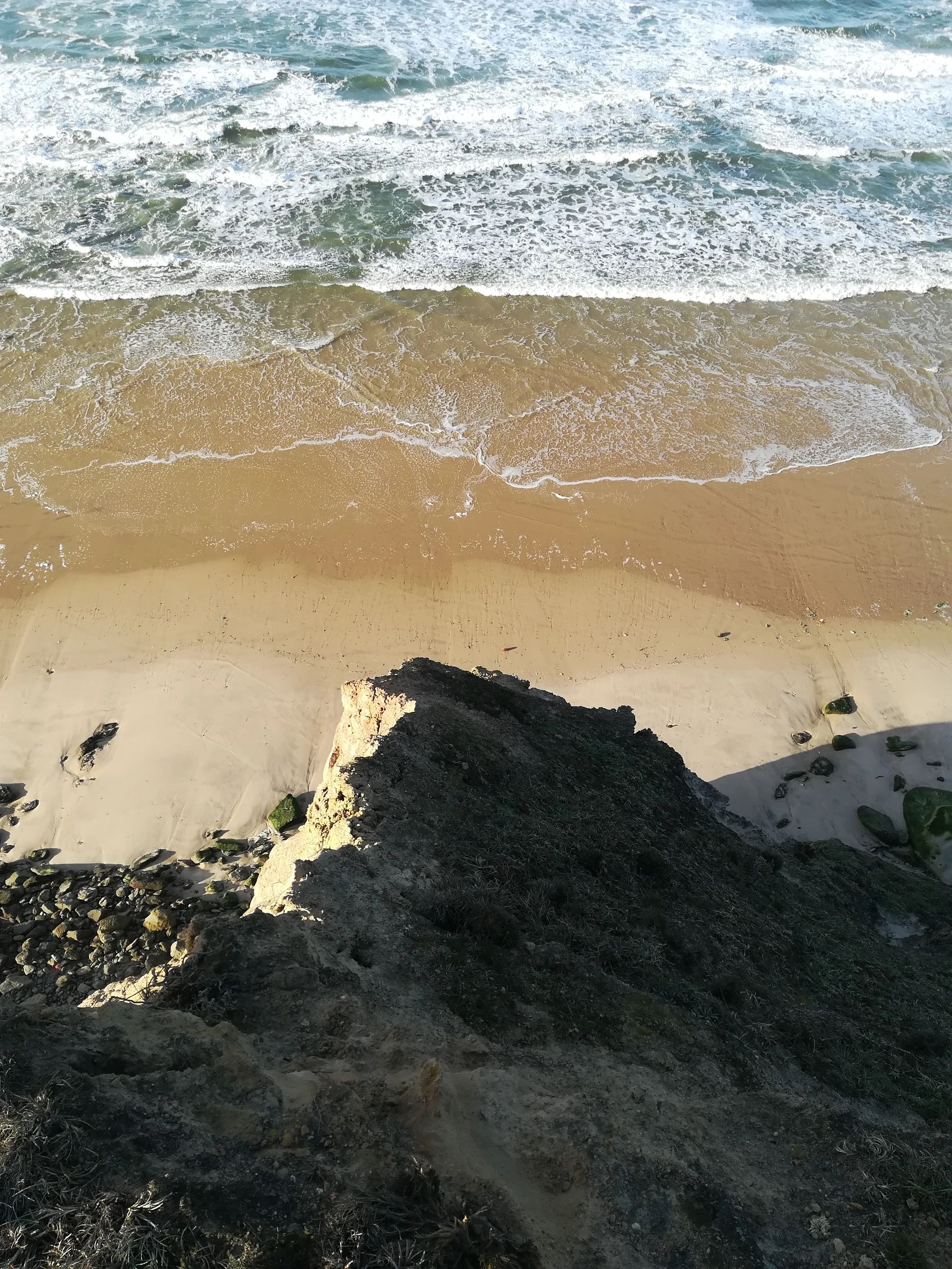 Blick von einer Klippe auf das Meer und den Sandstrand.