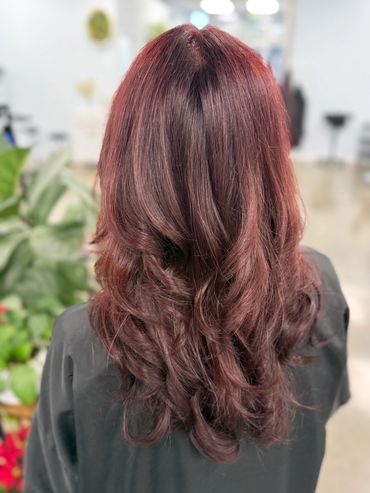 Shiny, wavy auburn hair styled smoothly from behind.