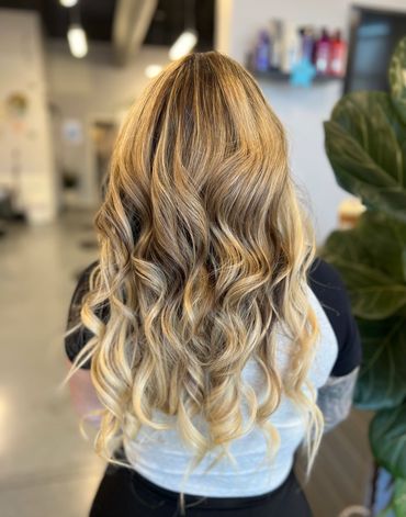 Back view of client with blond highlights and curls.