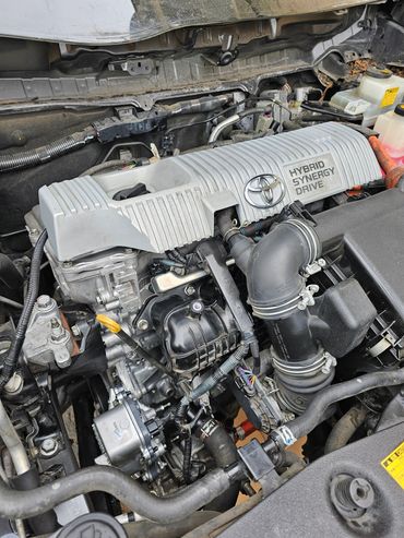 Close-up of a Toyota Hybrid Synergy Drive engine under the hood.