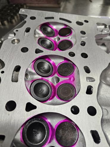 Close-up of a metal engine cylinder head with marked valve seats.