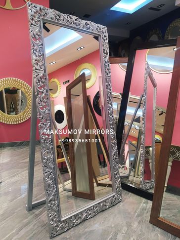 Decorative silver-framed mirror in a showroom.