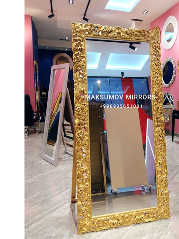 Ornate gold-framed mirror in a showroom.