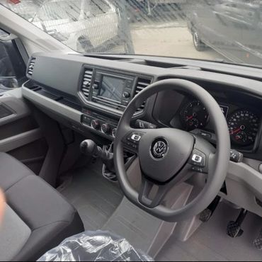 Interior of a Volkswagen vehicle with a steering wheel and manual transmission.