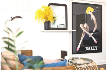 Bright living room corner with yellow flowers and modern art poster.
