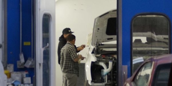 Two of our expert body technicians buff out a scratch at Denver’s best independent auto body repair.