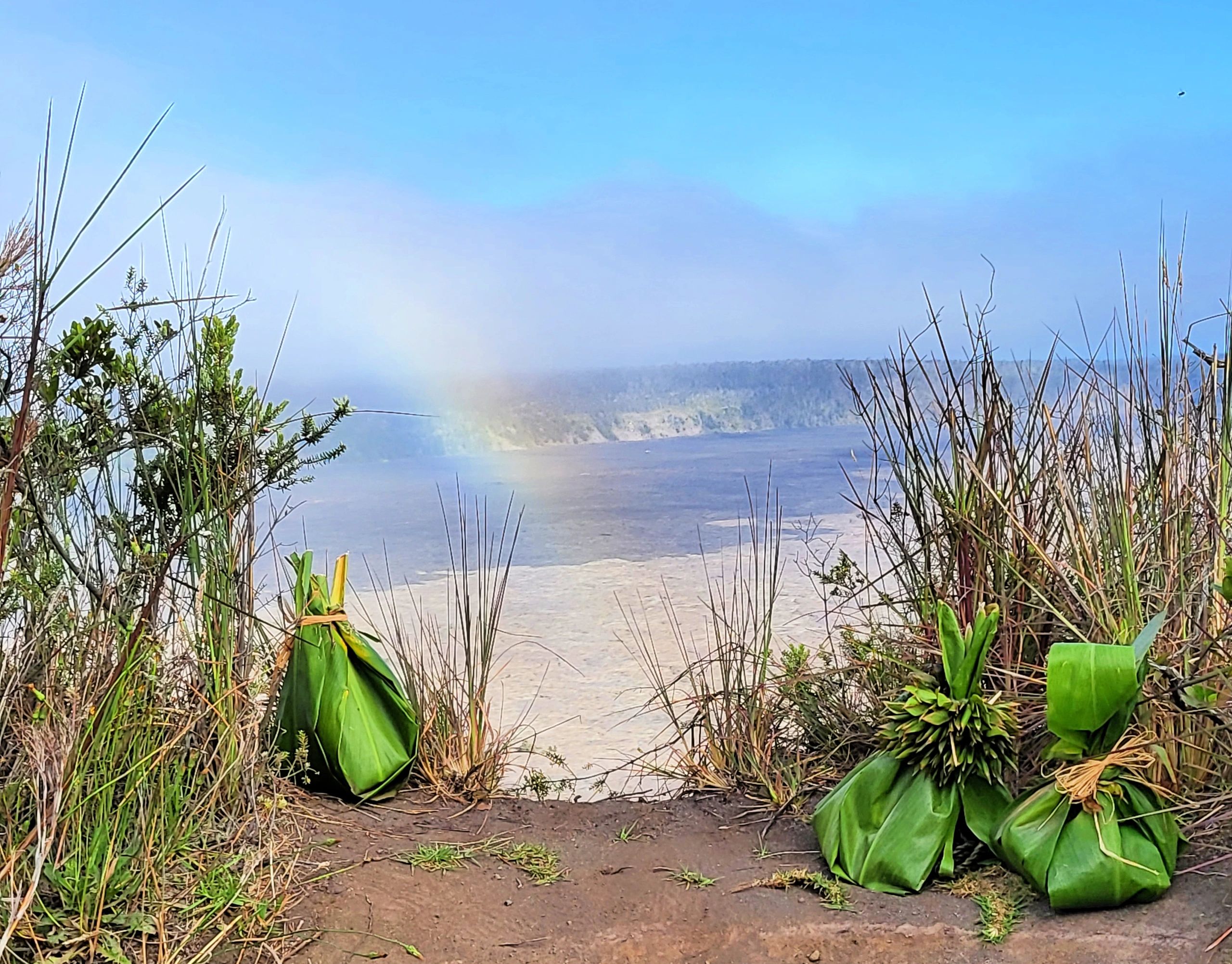 Rainbow over Kilauea crater with Pele gifts.