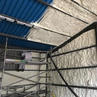 Industrial unit being insulated with HBS spray foam to walls and roof.