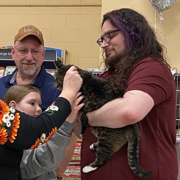 Volunteer Donovan Palmer showing a cat to potential adopters.