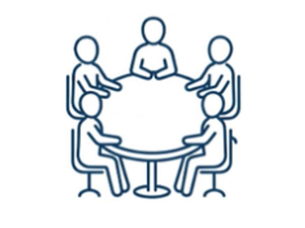 Five people sitting around a round table having a discussion.