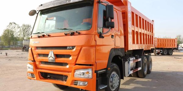 Bright orange heavy-duty dump truck parked outdoors.