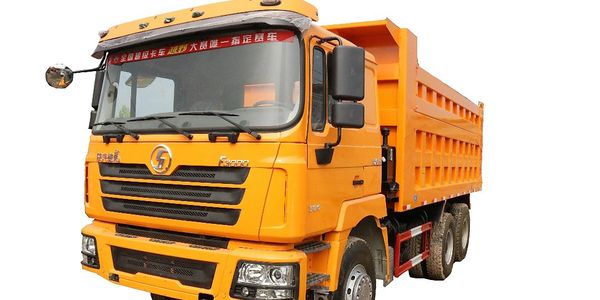 Bright orange heavy-duty dump truck isolated on white background.