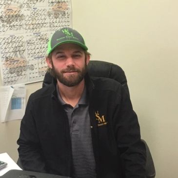 Man in a green cap smiling at the camera.