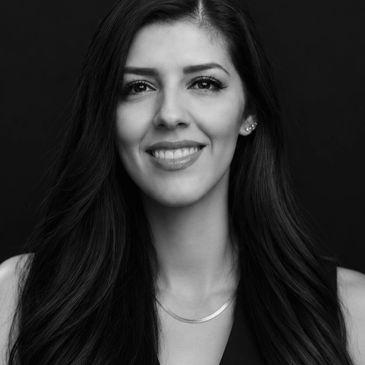 Black and white portrait of a smiling woman with long hair.