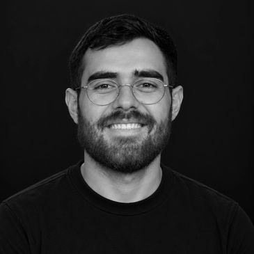 Smiling man with beard and glasses.