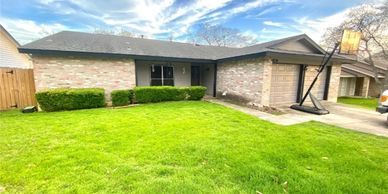Single-story brick house with a well-maintained front yard.