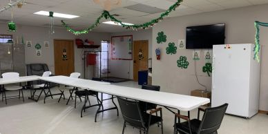 Room decorated with shamrocks and long tables.