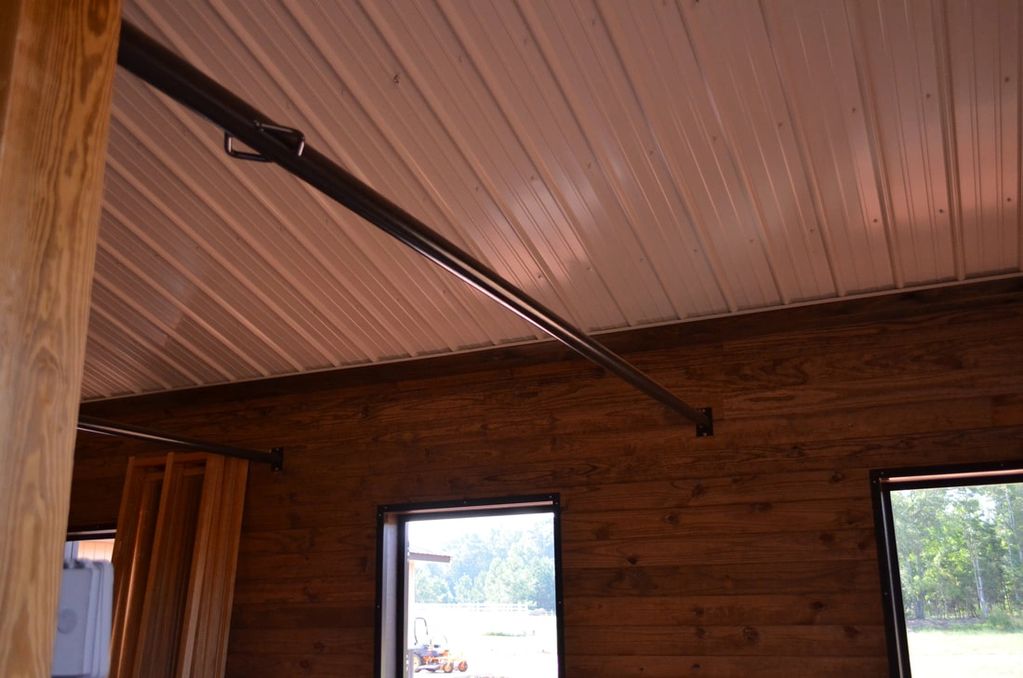 Wood-paneled room with metal ceiling and support beams.
